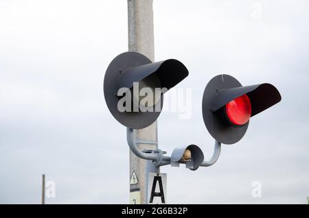 Square Grade crossing signal with red light gate and crossbuck at railroad crossing. Stock Photo