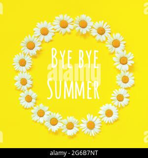 Goodbye Summer text and flower composition. Frame floral round wreath of flowers chamomile on yellow background. Greeting card. Stock Photo