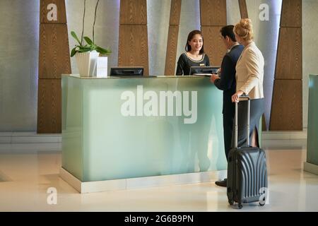 Business people and receptionist at modern lobby of business center building or hotel Stock Photo