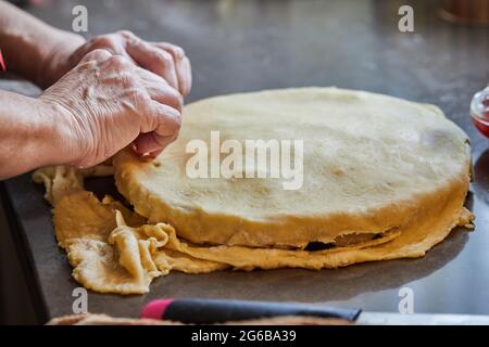 Chef is covering the filling for the chard pie with dough. Step by step recipe Stock Photo