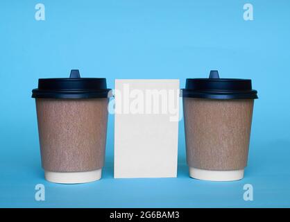 Two paper cups for coffee and a white cardboard card. Copy space Stock Photo