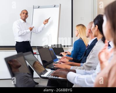 Business man doing presentation to colleagues in front of whiteboard Stock Photo