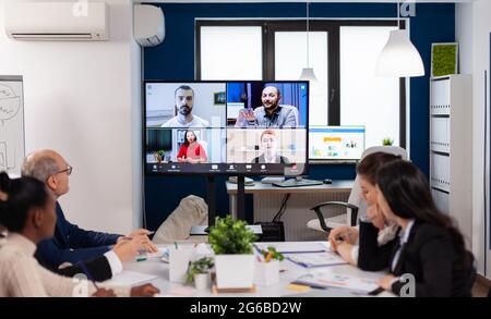 Team working by group video call share ideas brainstorming negotiating use video conference. Business people talking to webcam, do online conference participate internet brainstorming, distance office discussion. Stock Photo