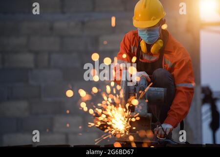 Manual working using a circular saw on a building site, Thailand Stock Photo
