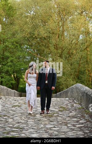 Portrait of a newly married couple walking across a bridge Stock Photo