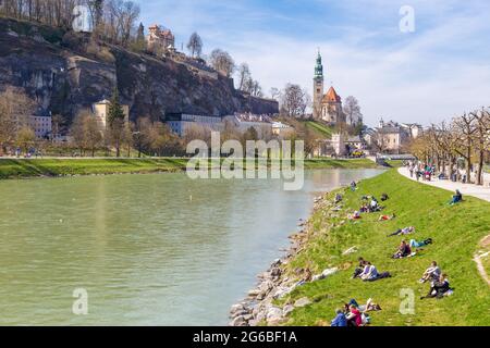 Salzburg, Austria - 9 April 2015 - People hang around along the river bank on a fine spring day in Salzburg, Austria on April 9, 2015 Stock Photo