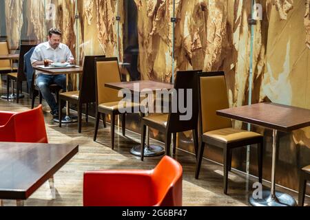 Munich, Germany - 17 April 2015 - Man sits along while having lunch in a restaurant in Munich, Germany Stock Photo