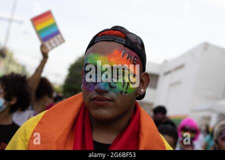 A demonstrator has his face painted with the LGTB flag colors and the word 'PRIDE' as thousands of members of Barranquilla, Colombia LGTBIQ communities participate in the international pride parade celebrated on June 26, 2021. Stock Photo