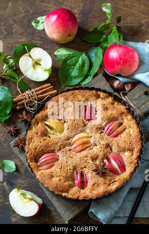 Apple baking gluten free seasonal. Autumn pie with apples, hazelnut and cinnamon on a wooden table. Stock Photo
