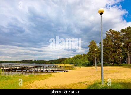 Augustow, Poland - June 1, 2021: Jetty pier and public beach at Necko lake shore in Masuria lake district resort town of Augustow in Podlasie region Stock Photo