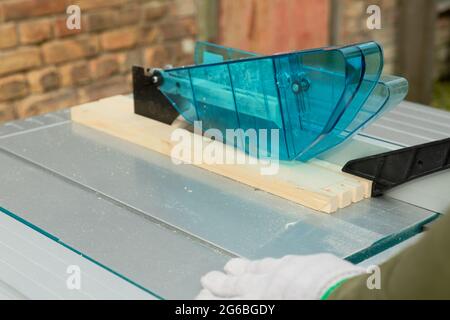 Handy man cutting wood on a table saw. Carpentry wood work. Stock Photo