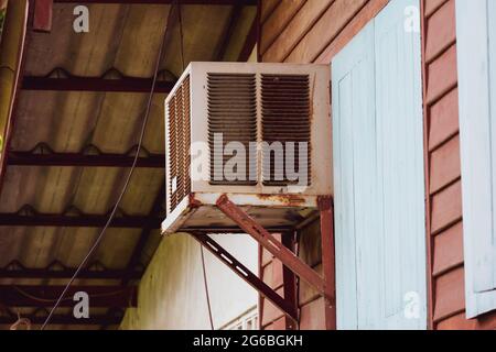 Old air conditioner next to the wall of a wooden house Stock Photo