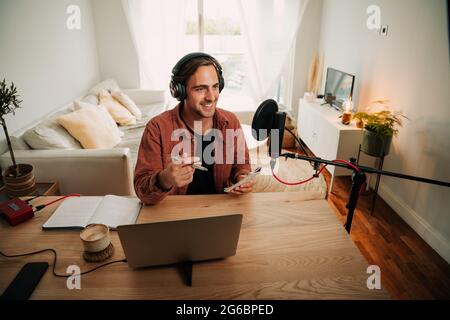 Caucasian male freelance worker speaking on podcast for audience  Stock Photo