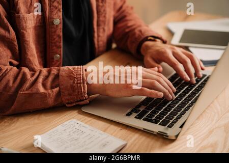 Close up caucasian male student typing on laptop at home  Stock Photo