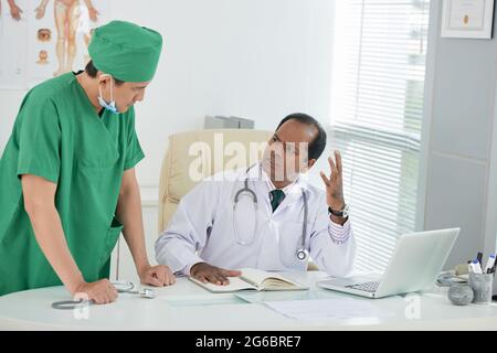 Emotional unhappy chief physician having serious conversation with doctor Stock Photo