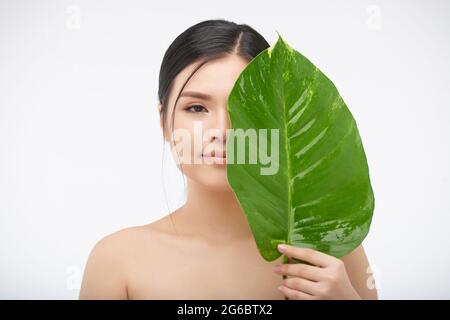 Portrait of the beautiful naked woman covering her body with green ...
