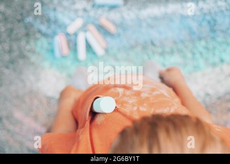 close up dirty chalk stains on children's clothes. a group of colored chalk and a painting rainbow on the background . High quality photo Stock Photo