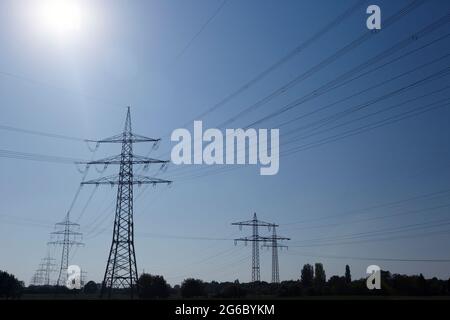 Electricity pylons against a clear blue sky on a sunny day Stock Photo