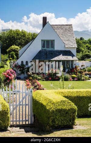 Front garden and Whitefriars cottage designed by Herbert Luck North in Arts and Crafts style on seafront promenade. Llanfairfechan Conwy Wales UK Stock Photo
