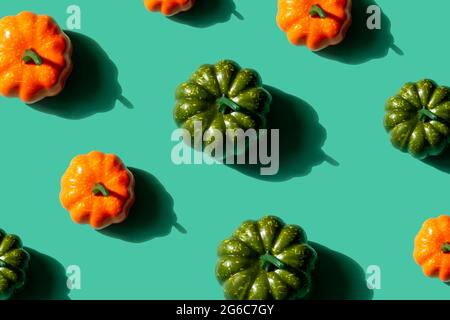 Pumpkins pattern on turquoise background. Orange and green pumpkins, halloween or autumn concept. Stock Photo