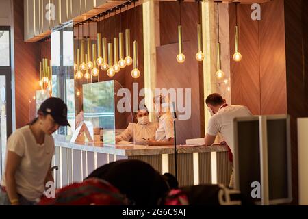 Alanya, Turkey - May 26: Masked caucasian women works at the hotel reception. High quality photo Stock Photo