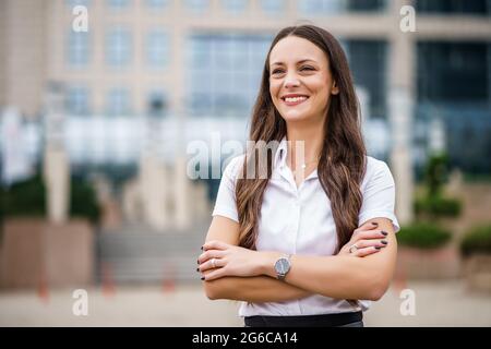 Portrait of happy businesswoman in front of company building. Stock Photo