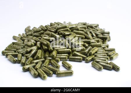 Green powdered herbal substance in a soft gel capsule Stock Photo