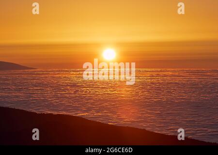 Sun above clouds. Mountain landscape at golden sunset. Tenerife, Canary Islands, Spain. Stock Photo