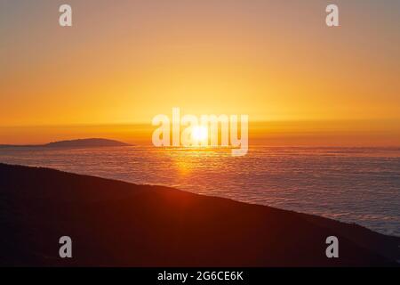 Sun above clouds. Mountain landscape at golden sunset. Tenerife, Canary Islands, Spain. Stock Photo