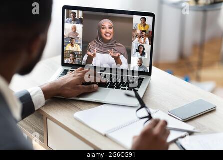 Back view of black businessman communicating with colleagues via video conference Stock Photo