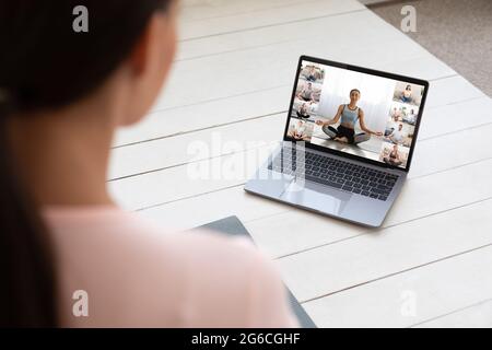 Fitness instructor teaching yoga online to group of young people Stock Photo