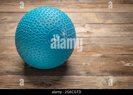 heavy rubber slam ball filled with sand on a rustic wooden deck, exercise and fitness concept Stock Photo