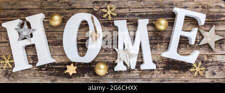 Home - white letters with gold christmas decoration on old wood Stock Photo
