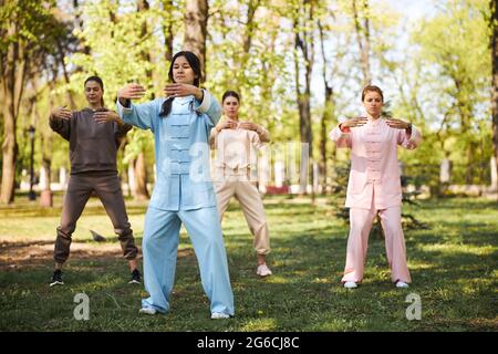 Females standing straight and stretching arms in front of themselves Stock Photo