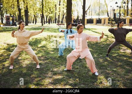 Wushu students standing in a fighting stance outside Stock Photo