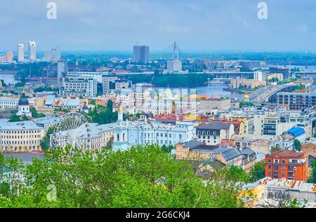 The roofs of historic Podil neighborhood, ferris wheel, Dnieper River and the Northern Bridge on horizon, Kyiv, Ukraine Stock Photo