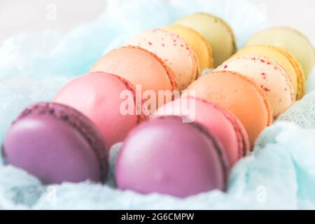 Box of fresh colorful french macarons. Shallow depth of field with selective focus on center macarons. Stock Photo