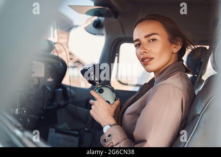 Attractive young woman sitting in aircraft pilot cabin Stock Photo