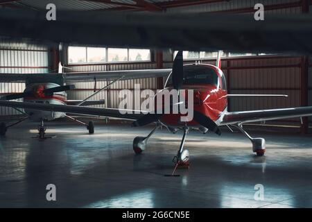 Two small red and white airplanes in airport hangar Stock Photo