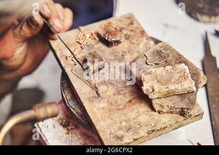 Jewelry making specialist using solder alloy on golden chain Stock Photo