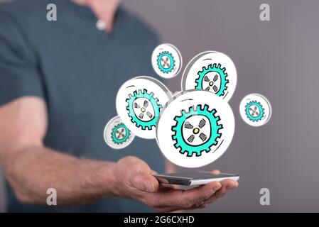 Business process concept above a smartphone held by a man in background Stock Photo