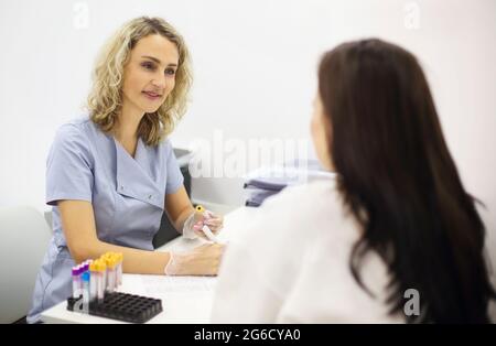Young female patient during blood test sampling procedure Stock Photo