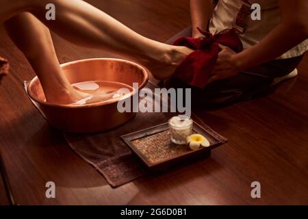 Woman washing foot in special container in spa salon Stock Photo
