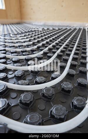 High angle of radiant heating systems with pipes installed on floor in contemporary wooden cottage Stock Photo