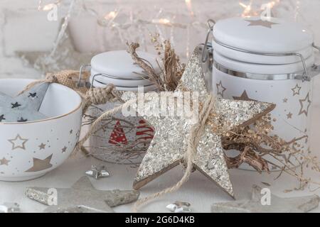 White porcelain jars and bowl with gold and silver christmas decoration and warm light Stock Photo