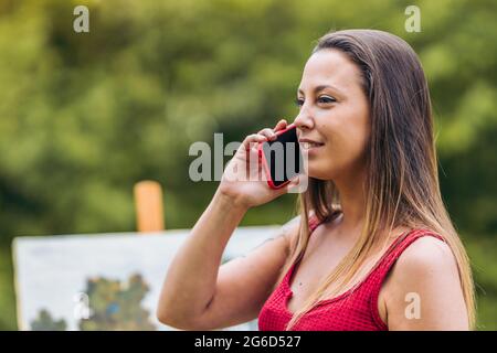 Artist talking with a mobile outdoors Stock Photo