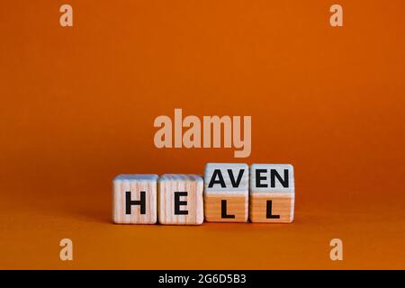 Hell or heaven symbol. Turned wooden cubes and changed the word 'hell' to 'heaven'. Business and religion concept. Beautiful orange background, copy s Stock Photo