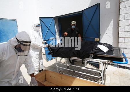 Kairouan, Tunisia. 1st Jan, 2000. (EDITORS NOTE: Image depicts death).Tunisian municipality employees prepare to place the body of a COVID-19 victim into a casket at the Ibn al-Jazzar hospital in the east-central city of Kairouan.Tunisia placed the capital Tunis and the northern town of Bizerte under a partial lockdown from July 14 in a bid to rein in record daily coronavirus cases and deaths. Credit: Jdidi Wassim/SOPA Images/ZUMA Wire/Alamy Live News Stock Photo