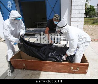 Kairouan, Tunisia. 1st Jan, 2000. (EDITORS NOTE: Image depicts death).Tunisian municipality employees place the body of a COVID-19 victim into a casket at the Ibn al-Jazzar hospital in the east-central city of Kairouan.Tunisia placed the capital Tunis and the northern town of Bizerte under a partial lockdown from July 14 in a bid to rein in record daily coronavirus cases and deaths. Credit: Jdidi Wassim/SOPA Images/ZUMA Wire/Alamy Live News Stock Photo