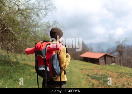 Concentrated young African American female with curly hair and closed eyes meditating at home while sitting legs crossed on table near red sofa Stock Photo